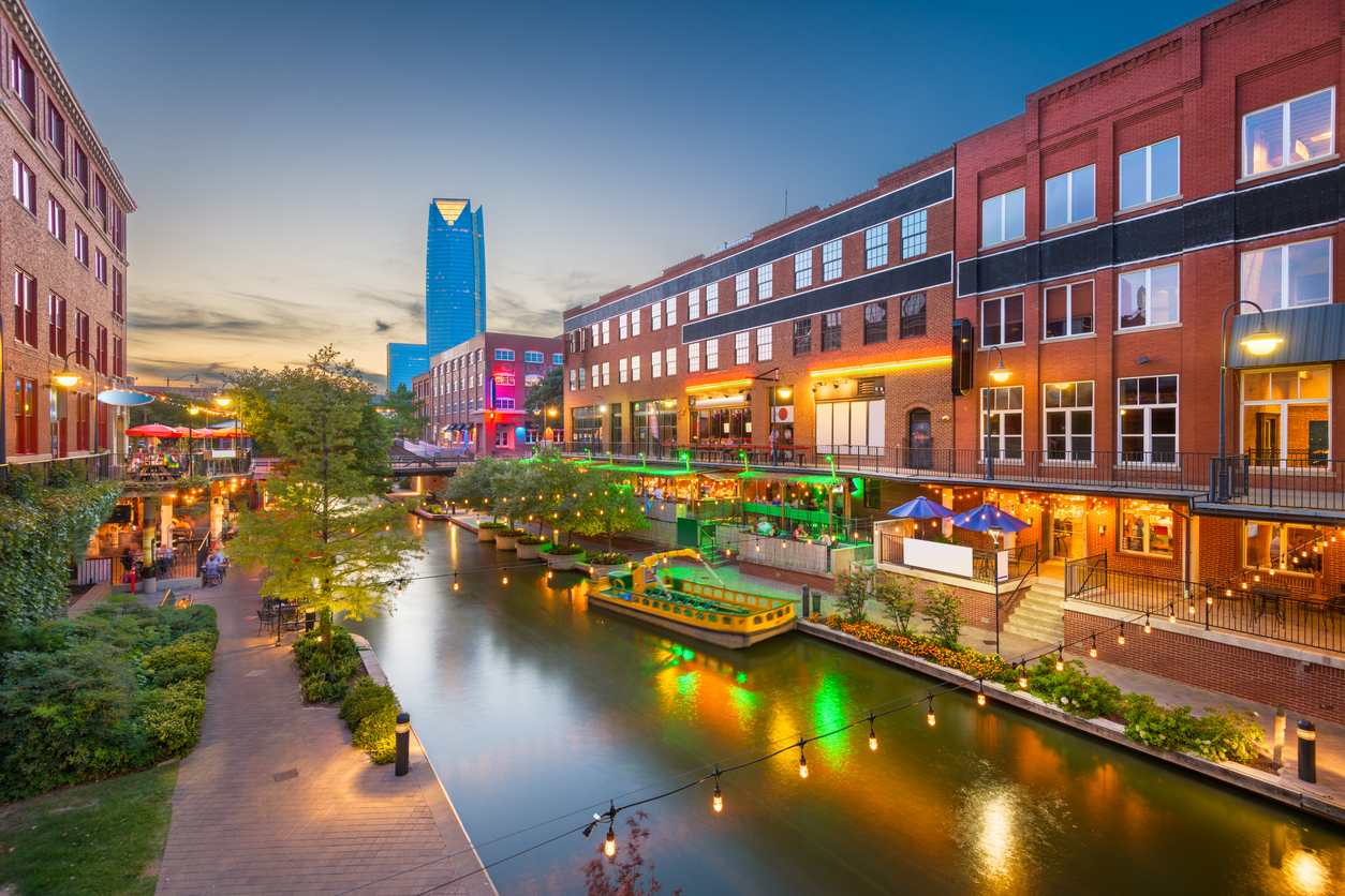 Bricktown in Oklahoma City, OK, in the evening, lit by string lights and walkway lights.