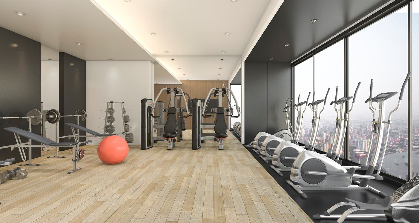 A gym located in a high-rise apartment community, featuring weight machines and ellipticals.