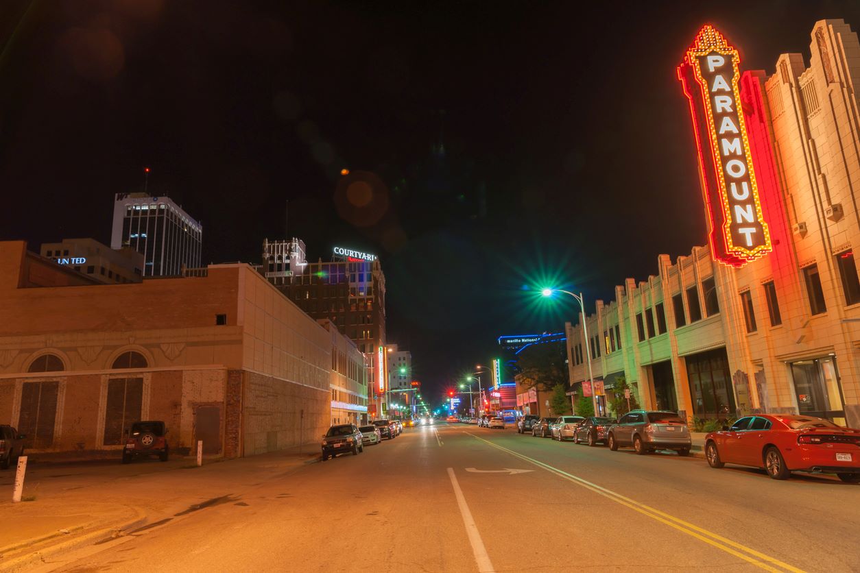 Downtown Amarillo at night with several lights and cars lining the street